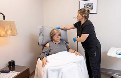 Nurse adjusting Infusion patient's pillow